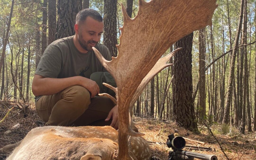 Julián, guía de Fawna, junto a un gamo tras un rececho en el pinar